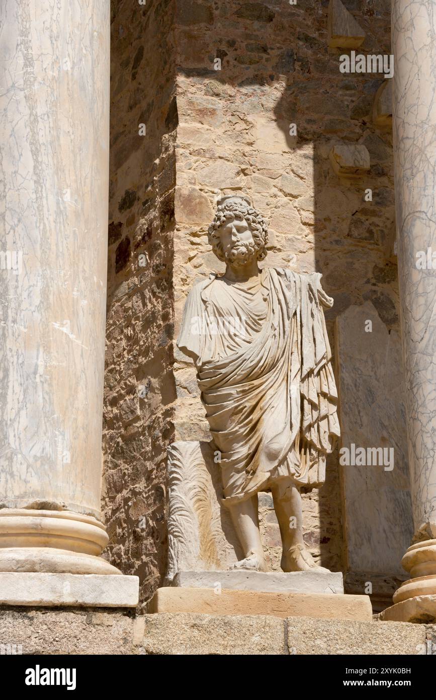 Steinstatue vor alten Säulen und Steinmauern, ein Detail der römischen Architektur und historischen Stätten, Teatro Romano de Merida, römisches Theater Stockfoto
