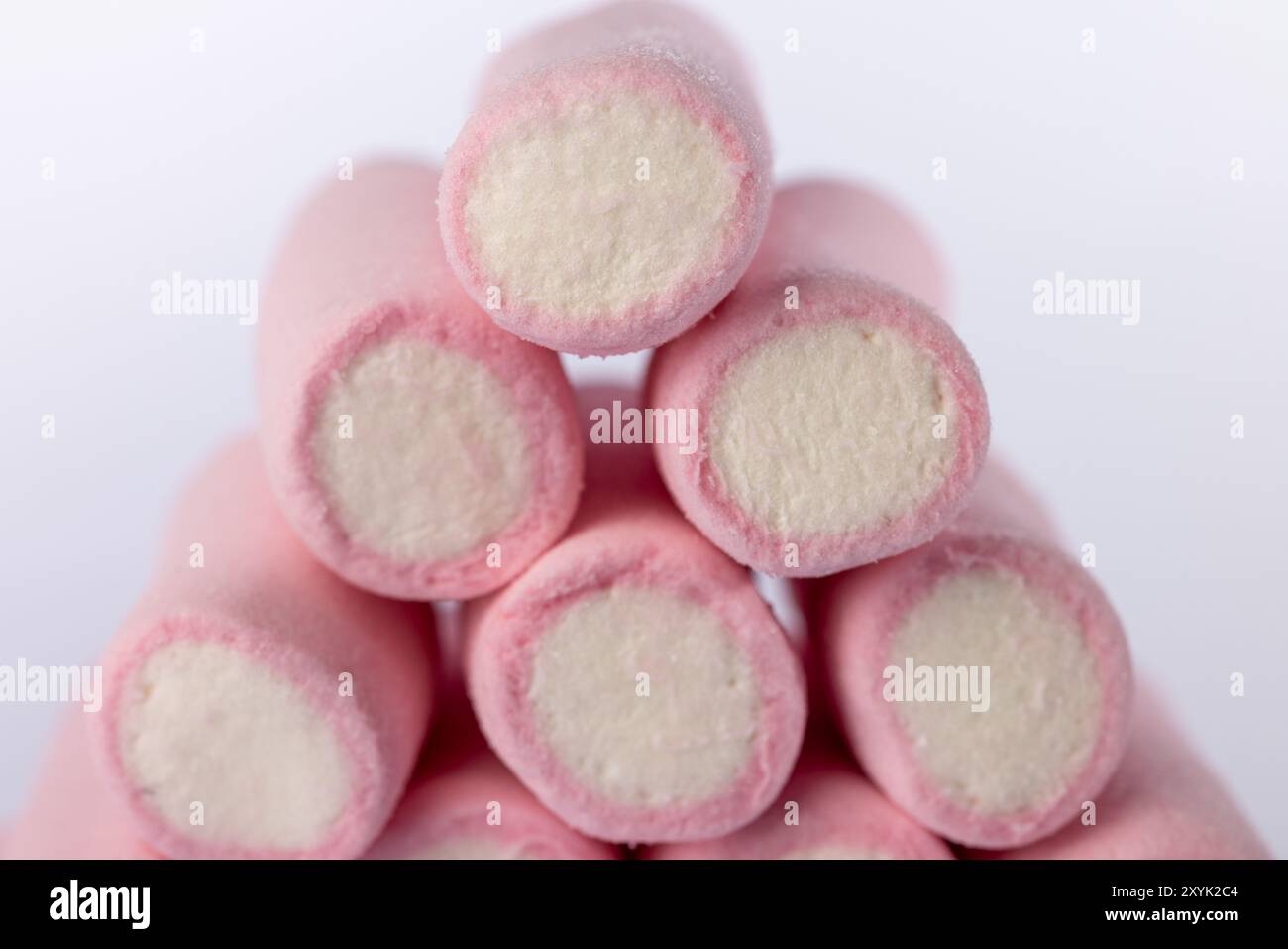 Nahaufnahme eines pyramidenförmigen Stapels von Marshmallows, zentral auf einem sauberen weißen Hintergrund platziert. Das Bild zeigt die weiche, weiße Textur und den Stru Stockfoto