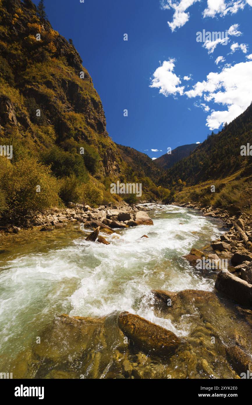 Ein eiskalter Alpenfluss aus dem himalaya fließt entlang der selten gesehenen Autobahn G318, einer Straße, die von Osttibet nach Lhasa führt, durch die HE Stockfoto