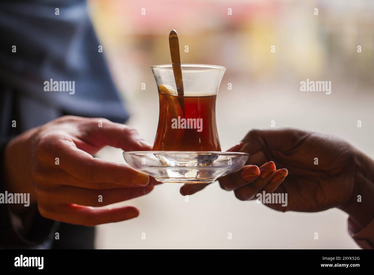 Hände halten ein Glas türkischen Tee aus Stockfoto