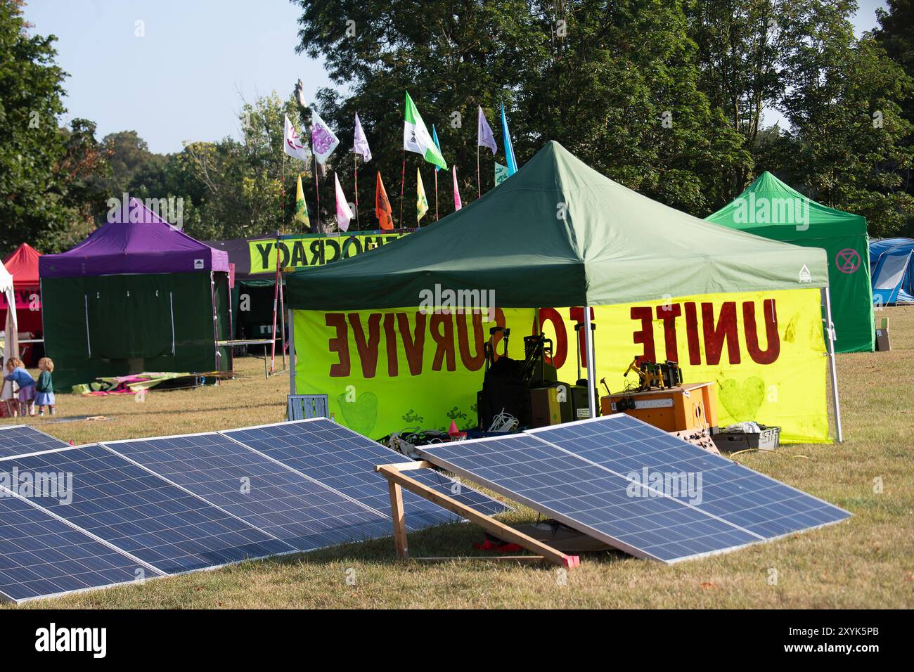 Windsor, Berkshire, Großbritannien. 30. August 2024. Ein Protestlager wird im Home Park in Windsor durch die Extinction Rebellion unter dem wachsamen Auge von Windsor Castle errichtet. Die Extinction Rebellion hält von heute bis Sonntag ein dreitägiges Aufrüsten der Demokratie in Windsor, Berkshire, ab. XR beschrieb das Ereignis als „die Demokratie aufrüsten“: „Es geht darum, gegen die systemischen Misserfolge der Regierung und die Lügen aufzubegehren, die ein ungerechtes System schaffen. Ein System, das es vermeidet, dringende Klimaschutzmaßnahmen zu ergreifen und das Leben vor Gier und Macht zu stellen." Proteste zelten im Home Park und werden va durchführen Stockfoto