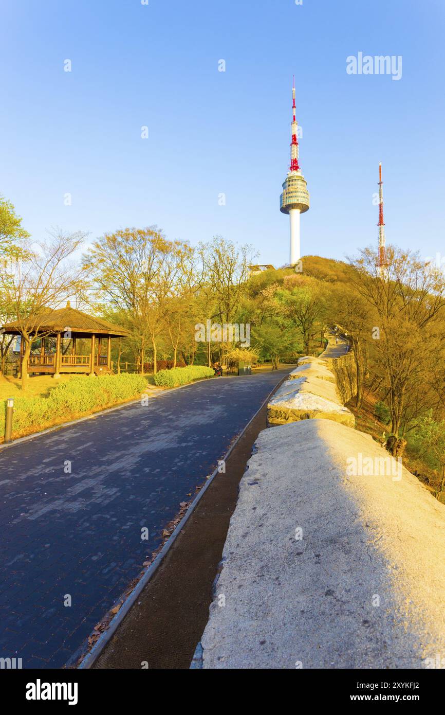 Fußweg und alte Stadtmauer führen an einem wolkenlosen, klaren Frühlingstag in Südkorea zum Gipfel des Namsan Berges N Seoul Tower. Vertikal Stockfoto