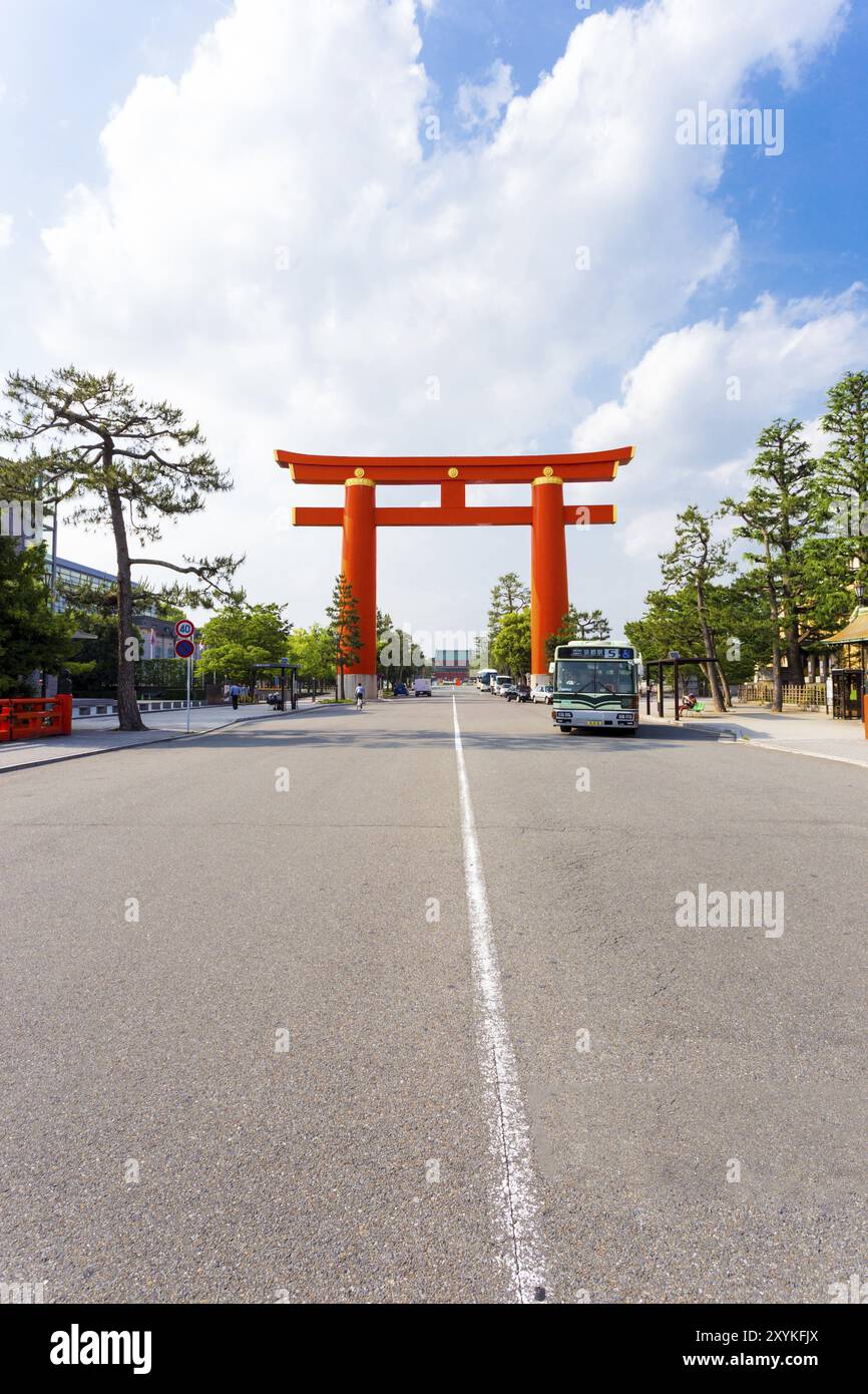 Ein großes oranges japanisches Torii-Tor auf der Jingu-Michi Straße umrahmt den historischen Heian-Schrein in der Ferne an einem sonnigen Tag in Kyoto, Japan. Vertikaler Cop Stockfoto