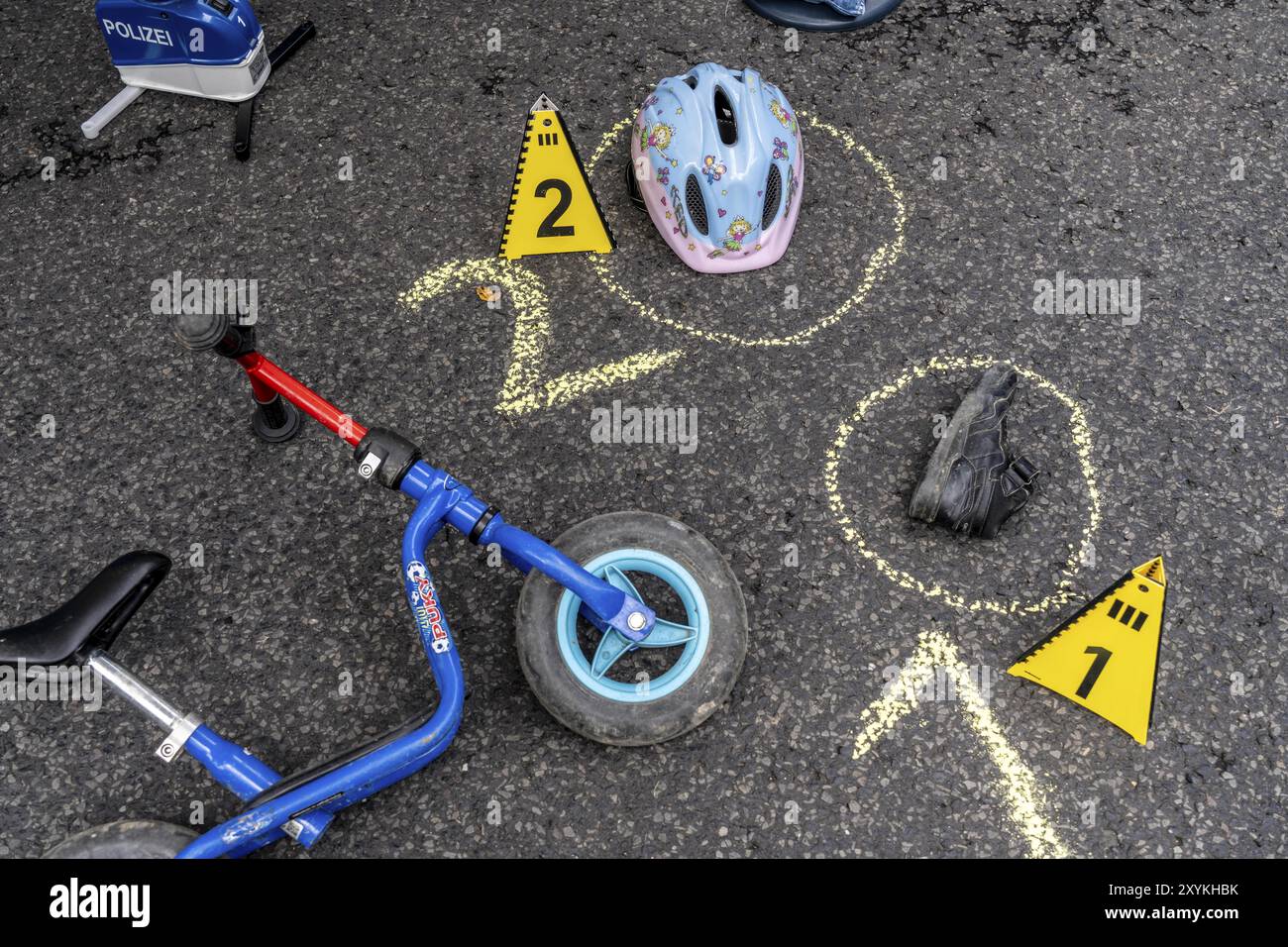 Markierungen an einem Unfallort mit Kinderwaagerad, Helm, nachgeahmter Unfallaufzeichnung, bei einer öffentlichen Veranstaltung der Kölner Polizistin Stockfoto