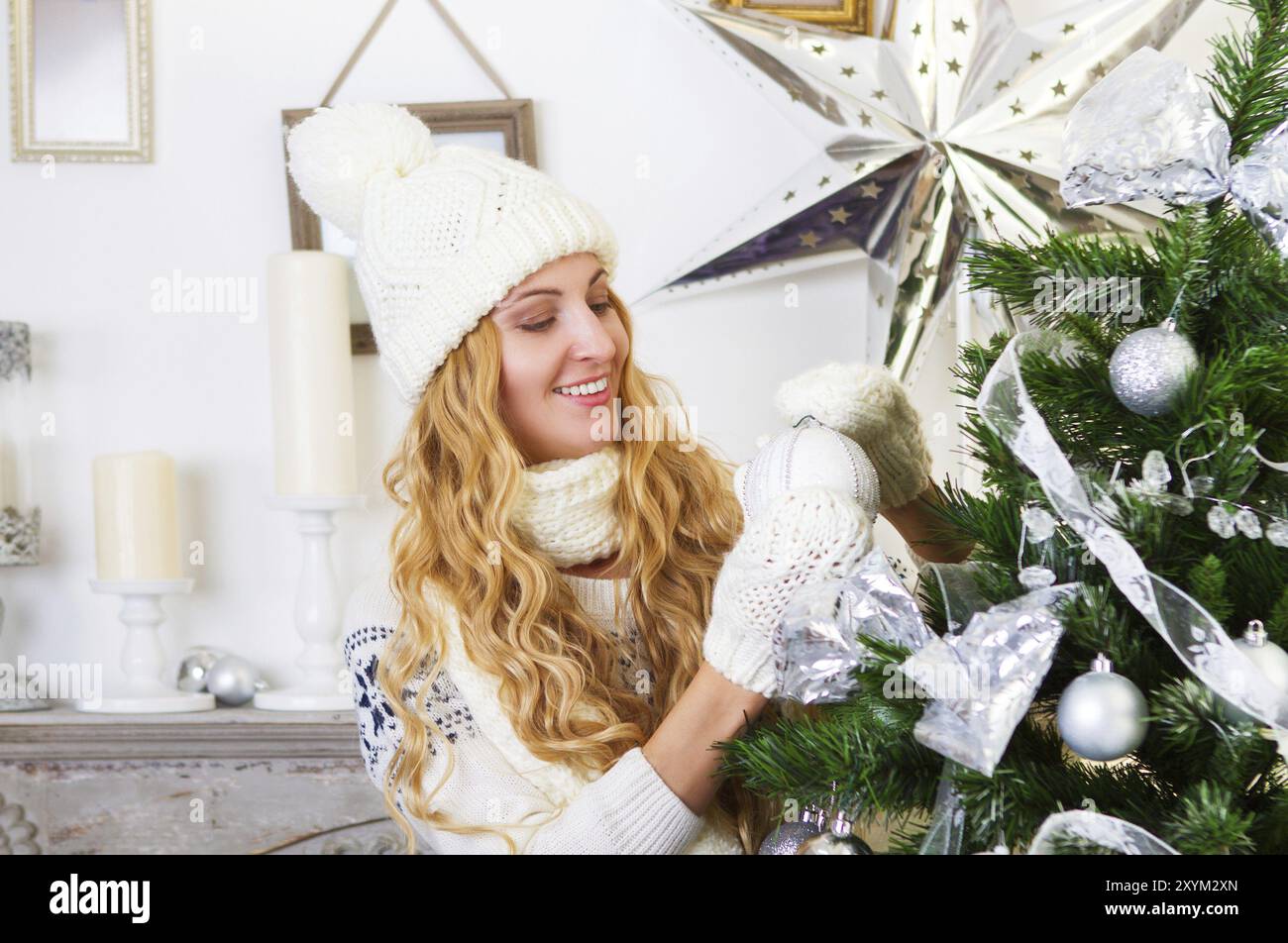 Schöne junge Frau trägt weiße Dekoration Weihnachtsbaum Stockfoto