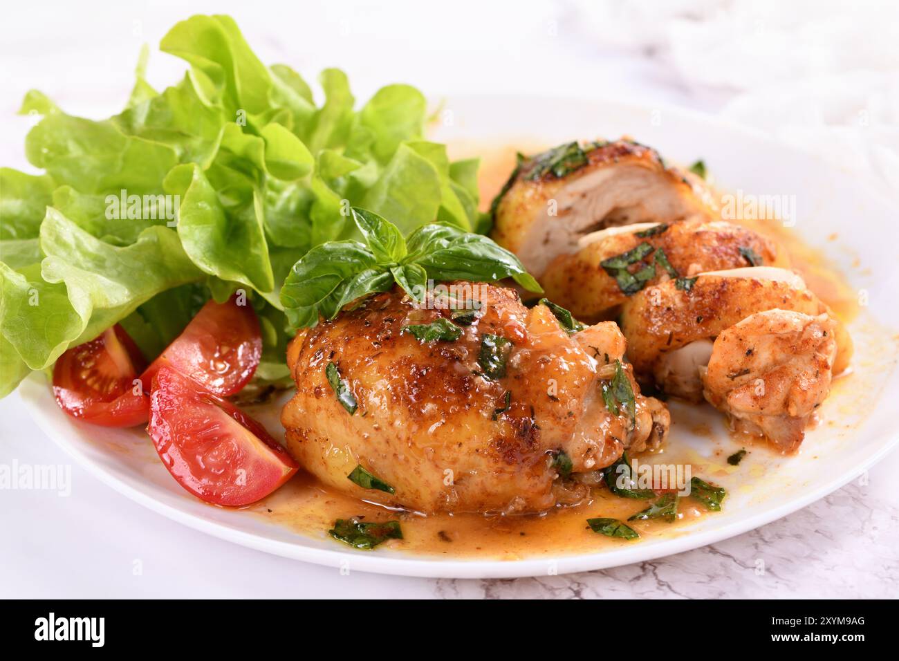 Hähnchenschenkel mit Soße und Beilage mit Gemüse Stockfoto