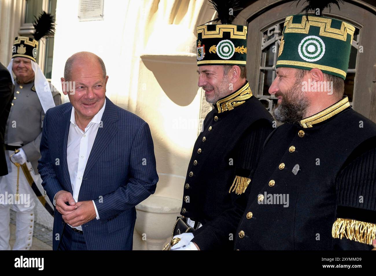 Freiberg, Deutschland. 30. August 2024. Bundeskanzler Olaf Scholz (SPD, 2. V. l.) besucht das Oberbergamt in Freiberg, das für die Förderung und Regulierung des Bergbaus einschließlich der Lithiumgewinnung im Erzgebirge zuständig ist, und spricht mit zwei Männern, die ihn in traditionellen Bergmannskostümen begrüßen. Quelle: Sebastian Willnow/AP Pool/dpa/Alamy Live News Stockfoto
