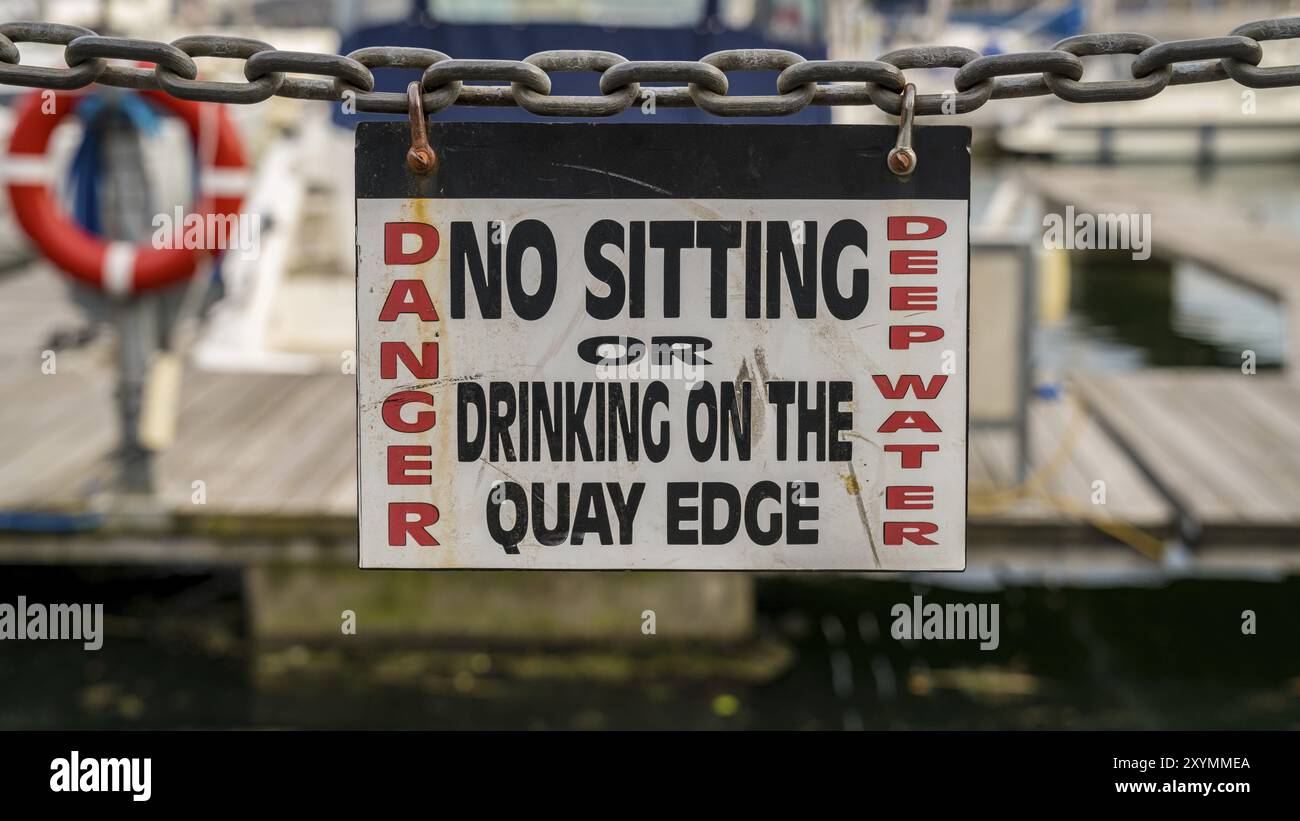 Zeichen: Gefahr nicht sitzen oder Trinken auf dem Kai Kante, in Ipswich, Suffolk, England, UK gesehen Stockfoto