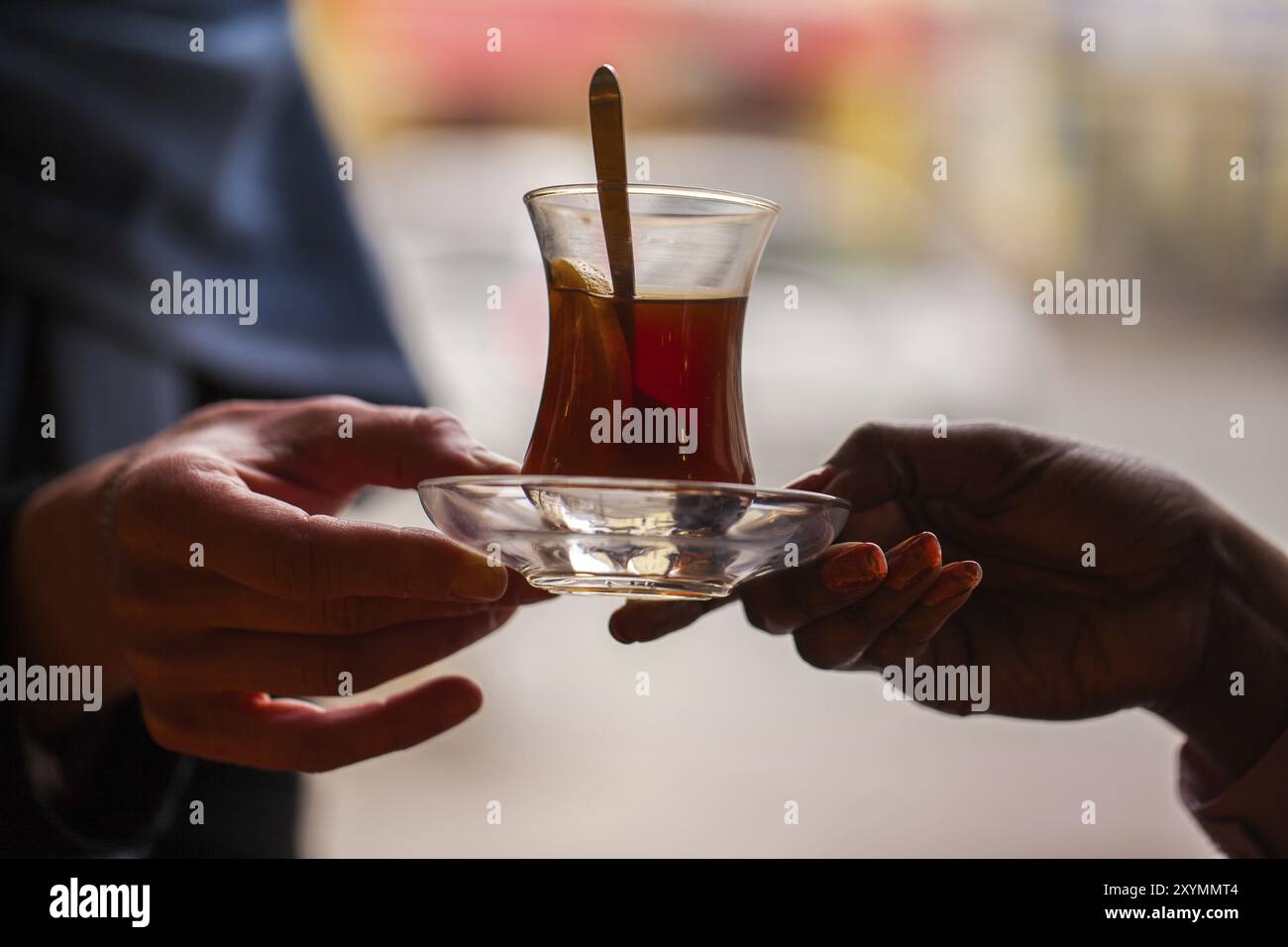 Hände halten ein Glas türkischen Tee aus Stockfoto
