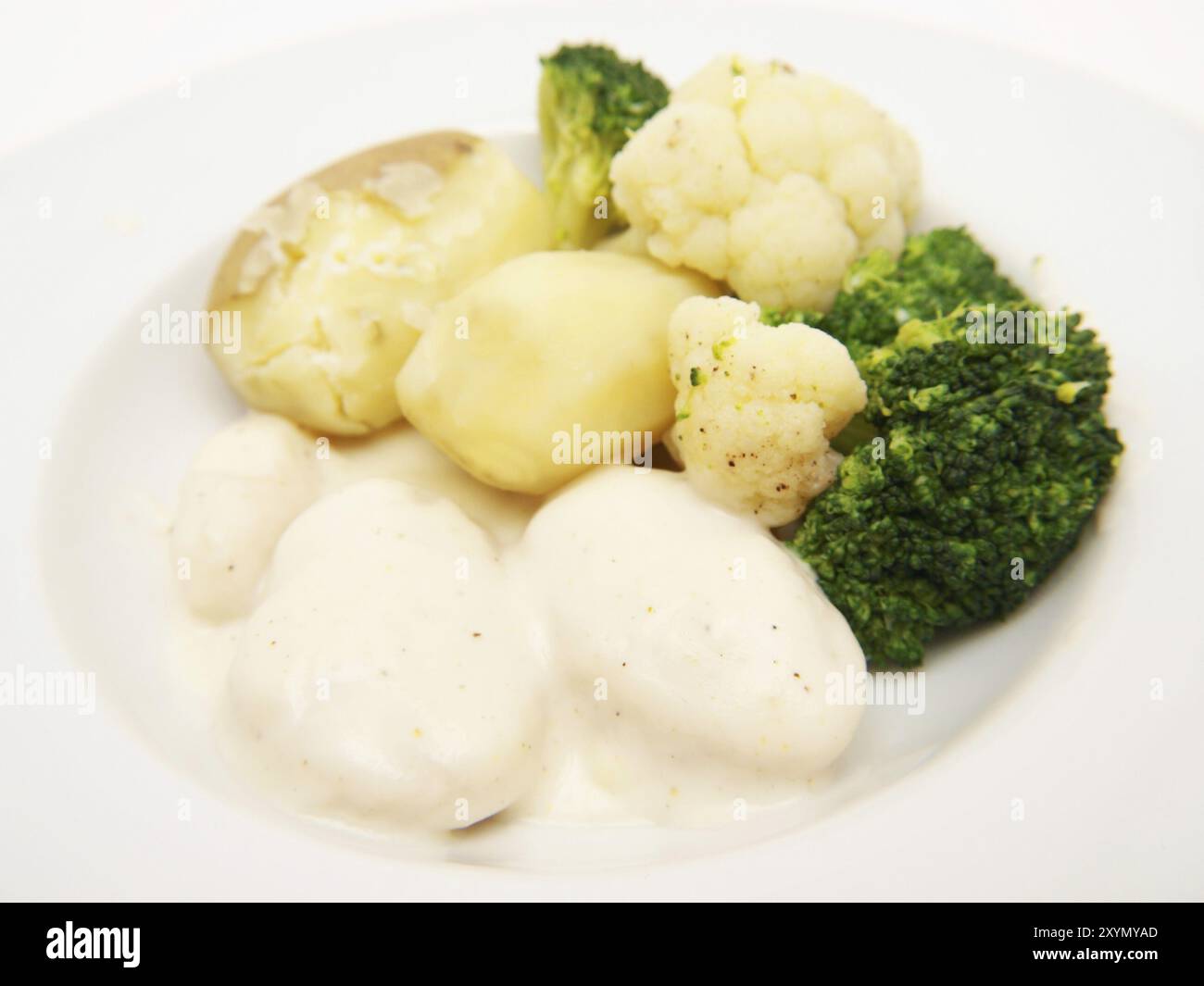 Fischbällchen in weißer Soße, mit Kartoffeln, Brokkoli und Blumenkohl Stockfoto