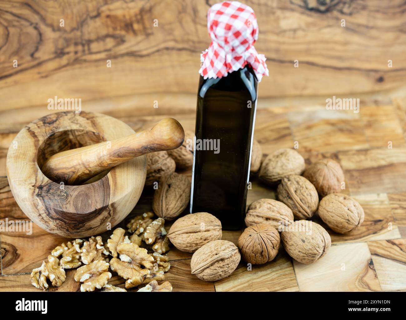 Walnuss (Juglans regia), ganze und gekrackte Walnüsse, Walnussöl und Mörtel Stockfoto