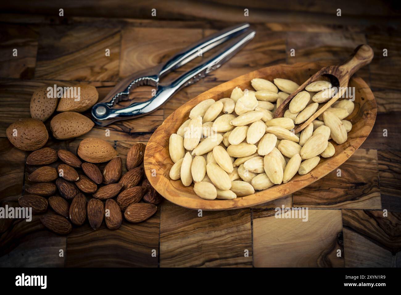 Mandel (Prunus dulcis, Prunus amygdalus, Amygdalus communis, Amygdalus dulcis), Mandel, mit Schale, gerissen und blanchiert auf einem Teller, Nussknacker Stockfoto