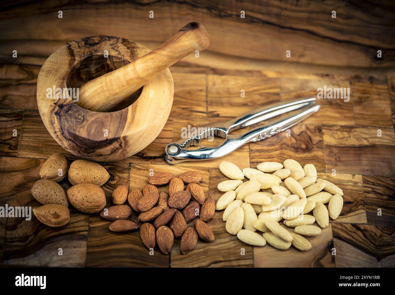Mandel (Prunus dulcis, Prunus amygdalus, Amygdalus communis, Amygdalus dulcis), Mandel, mit Schale, gerissen und blanchiert, mit Mörtel und Nussknacker Stockfoto