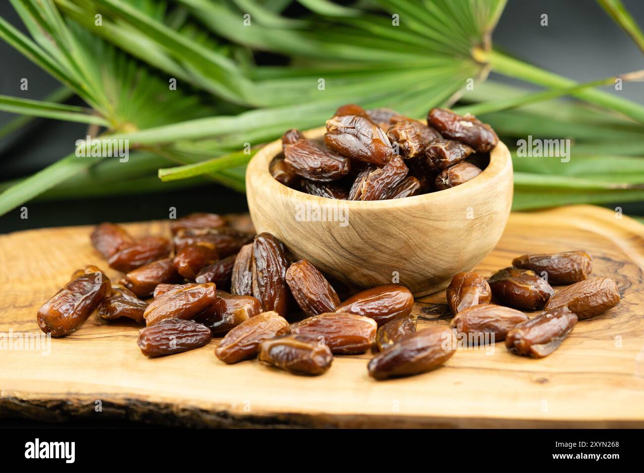 Datteln in einer Holzschale mit Palmblatt Stockfoto