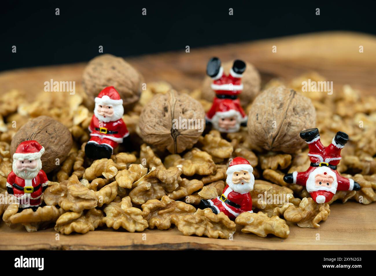 Walnuss (Juglans regia), zerbrochene Walnüsse und ganze Nüsse mit kleinen Santas Stockfoto