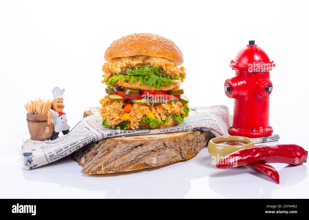 Gegrillter Chicken Burger mit frischem Gemüse auf einem Holzbrett Stockfoto