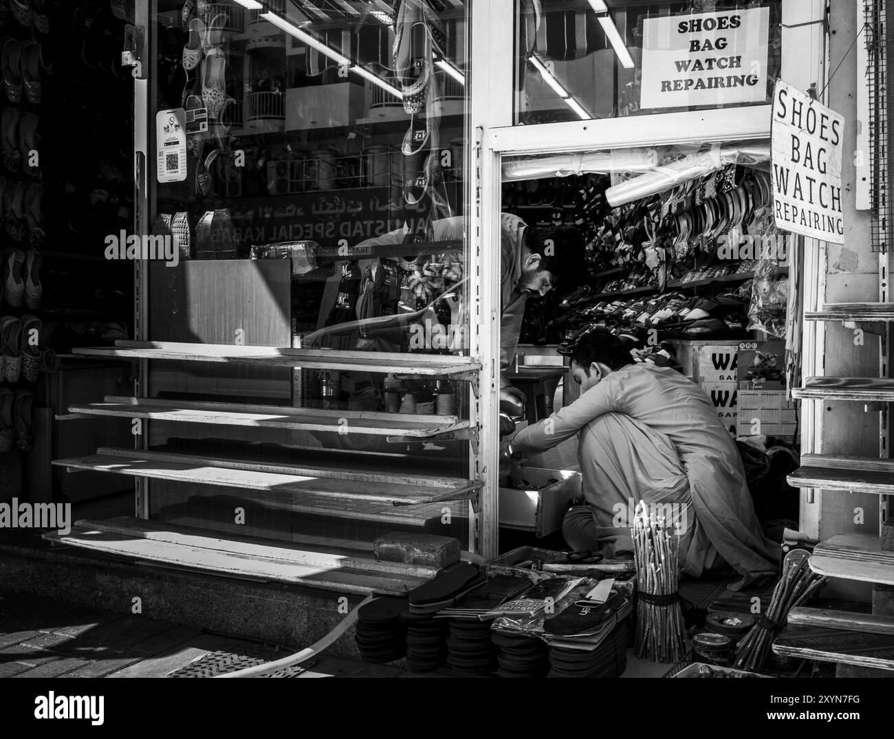 Schwarzweiß-Fotografie, Schuhgeschäfte und Handwerker im Viertel Al Fahidi, Dubai, Vereinigte Arabische Emirate, Asien Stockfoto