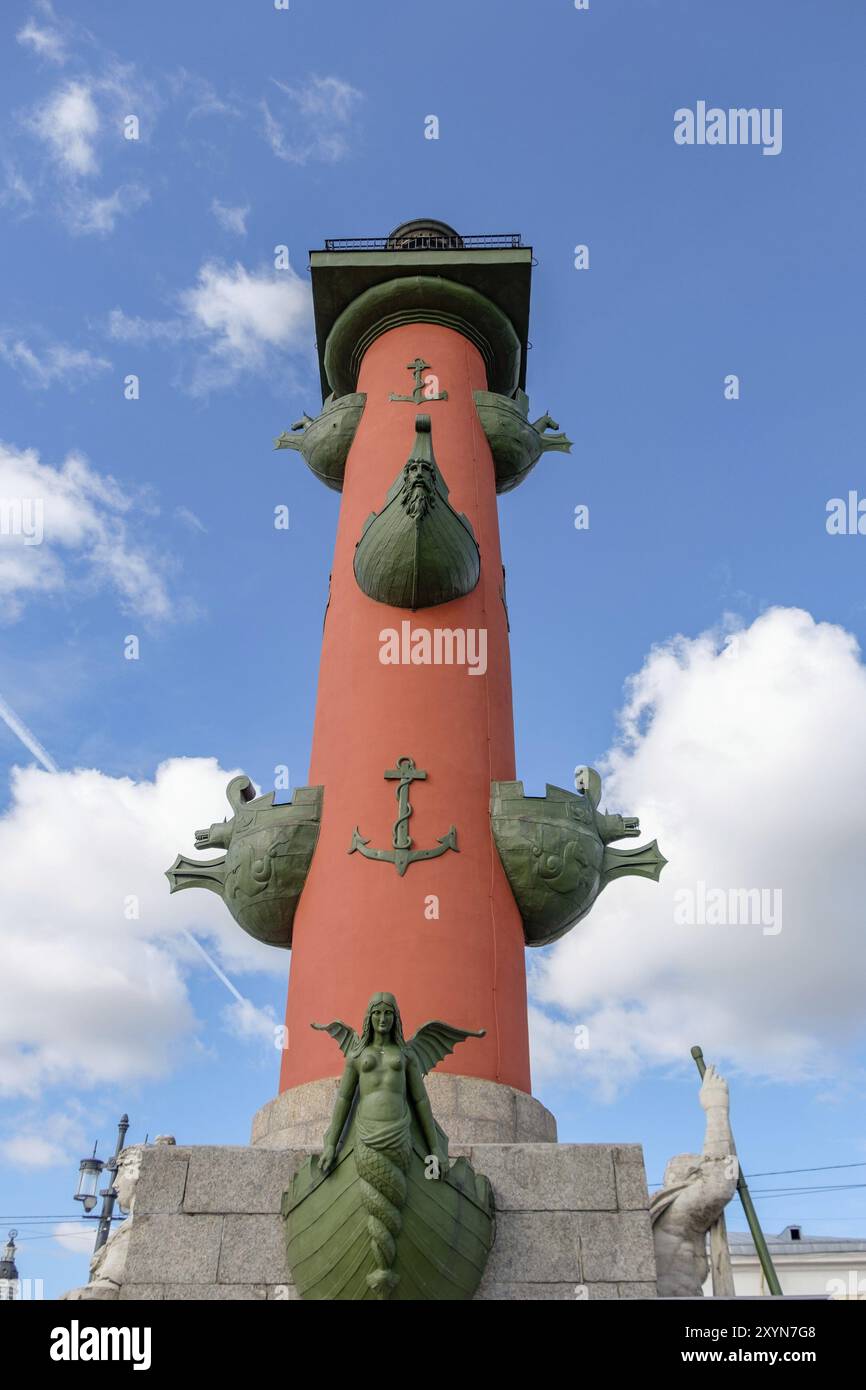 Ein markanter roter Leuchtturm mit grünen Drachenköpfen und Statuen unter einem leicht bewölkten Himmel, sankt petersburg, ostsee, russland Stockfoto