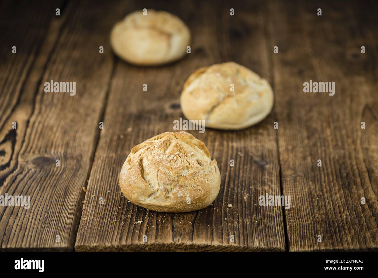 Frisch zubereitete deutsche Brötchen auf einem alten und rustikalen Holztisch, selektiver Fokus, Nahaufnahme Stockfoto