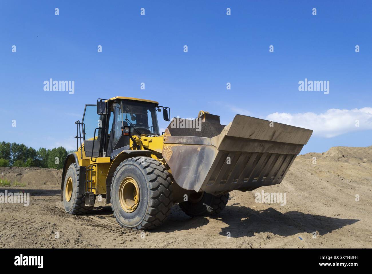 Ein Radlader, der auf einer Baustelle verwendet wird. Ein Schwerlader, eine schwere Maschine, die im Bau- und Gehsteig zum Beladen der Erde eingesetzt wird, s Stockfoto