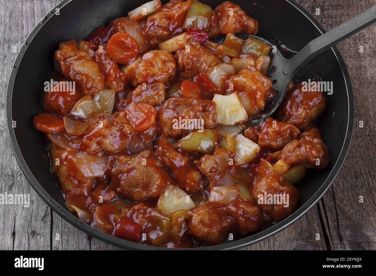 Süßes und saures Schweinefleisch in einem Kochwok Stockfoto