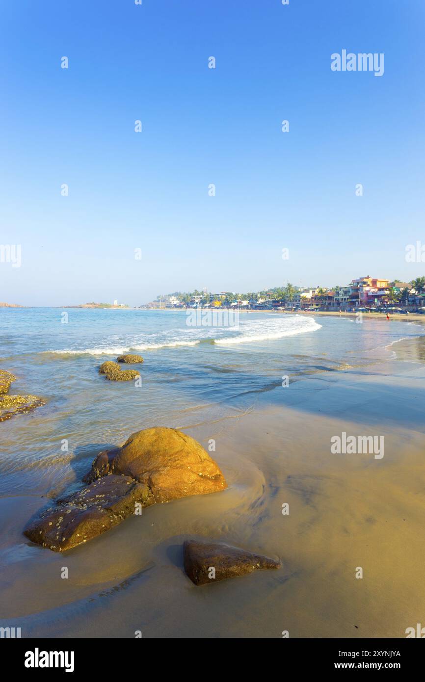 Kovalam, Indien, 1. März 2015: Hotels säumen den Strand über dem Sand am Light House Beach und Meereswellen in einer Touristenstadt in Kerala, Indien. Vert Stockfoto