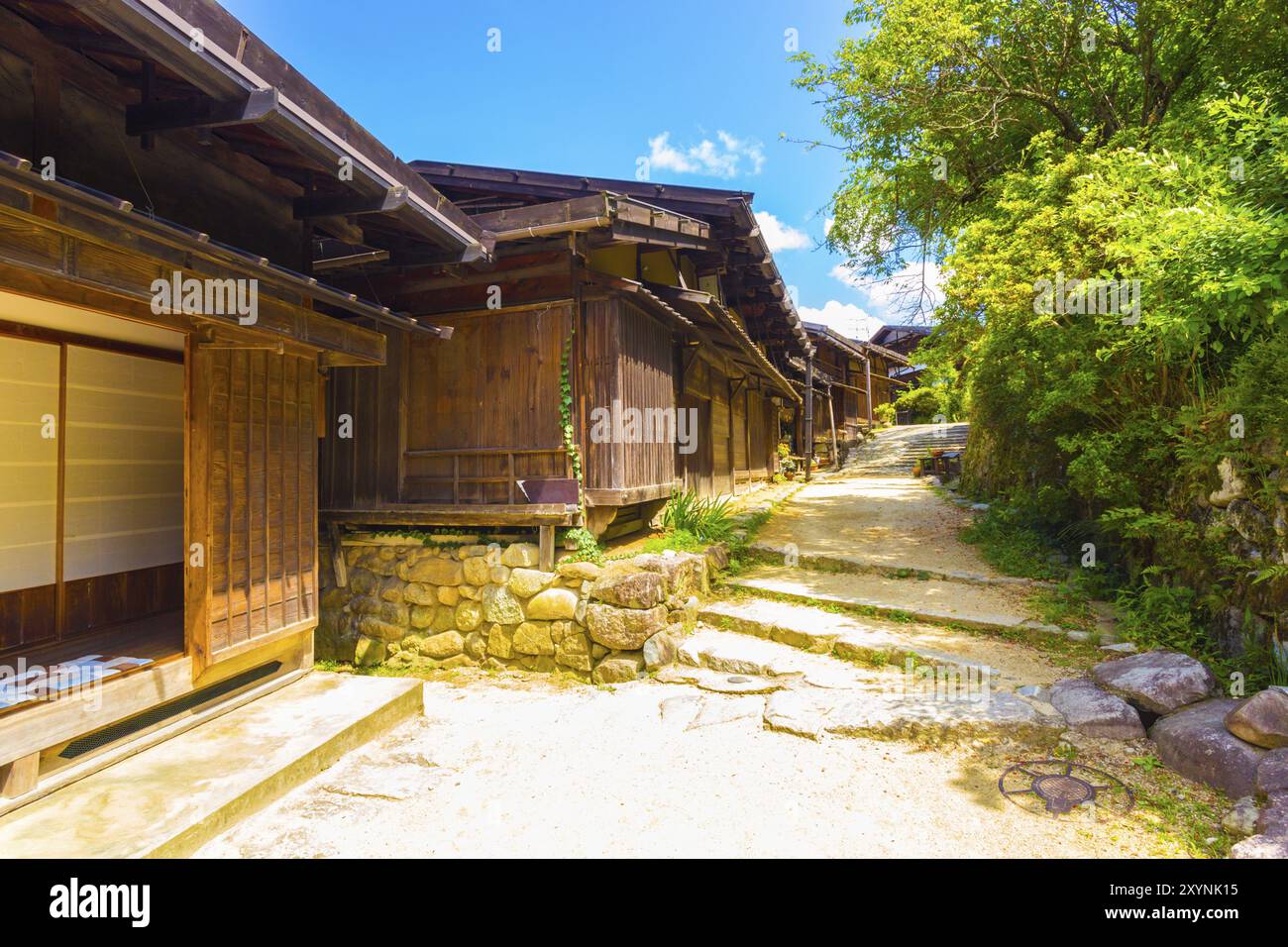 Eine Reihe von bukolischen Holzhäusern und unbefestigten Straßen, die auf der Nakasendo-Route im Dorf Tsumago in einem alten japanischen Landgefühl restauriert wurden Stockfoto