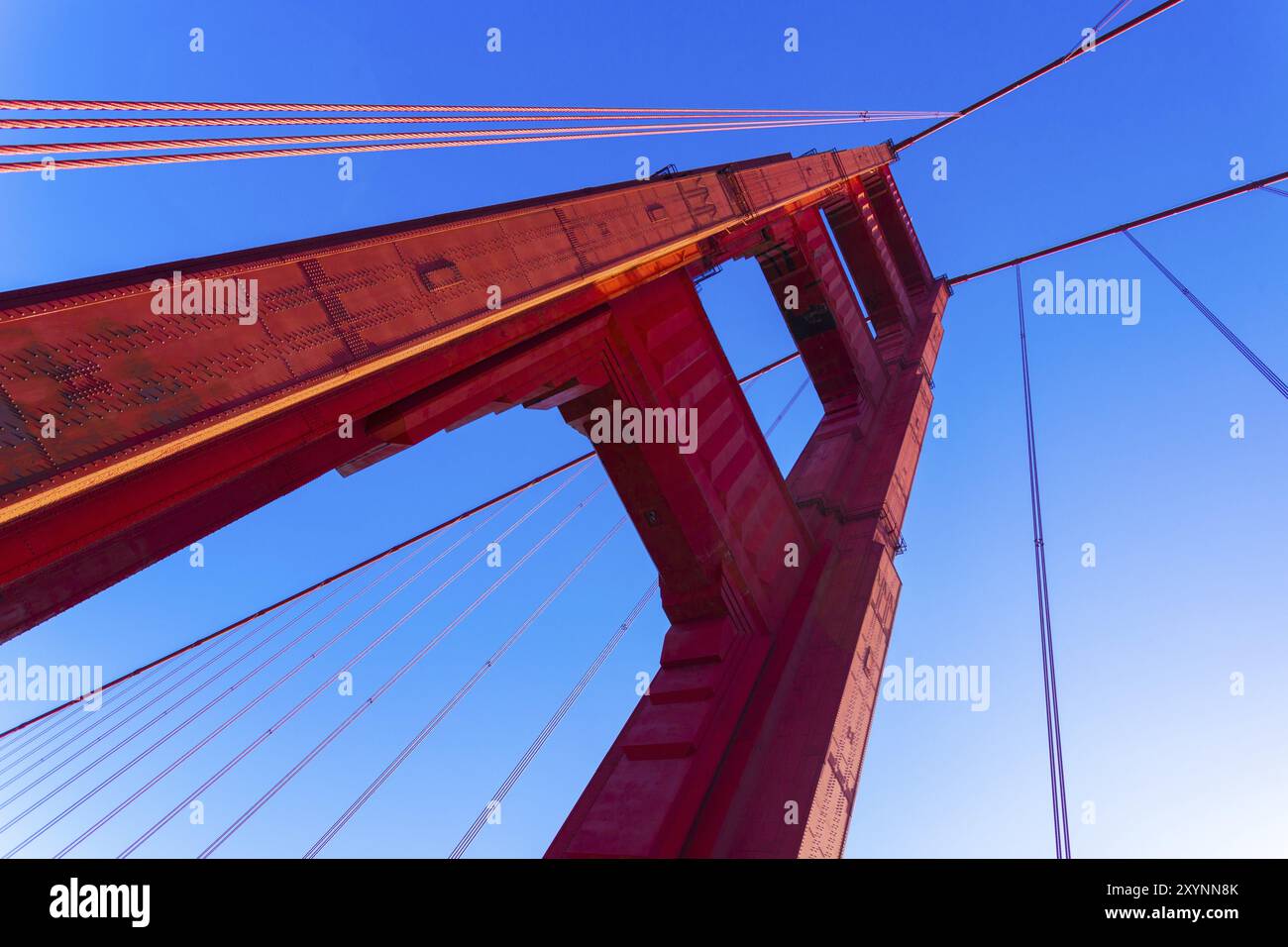 Niedrigen Winkel Closeup Detailansicht der rote Golden Gate Bridge Tower und Kabel vor einem blauen Himmel in der Nähe von San Francisco, Kalifornien Stockfoto