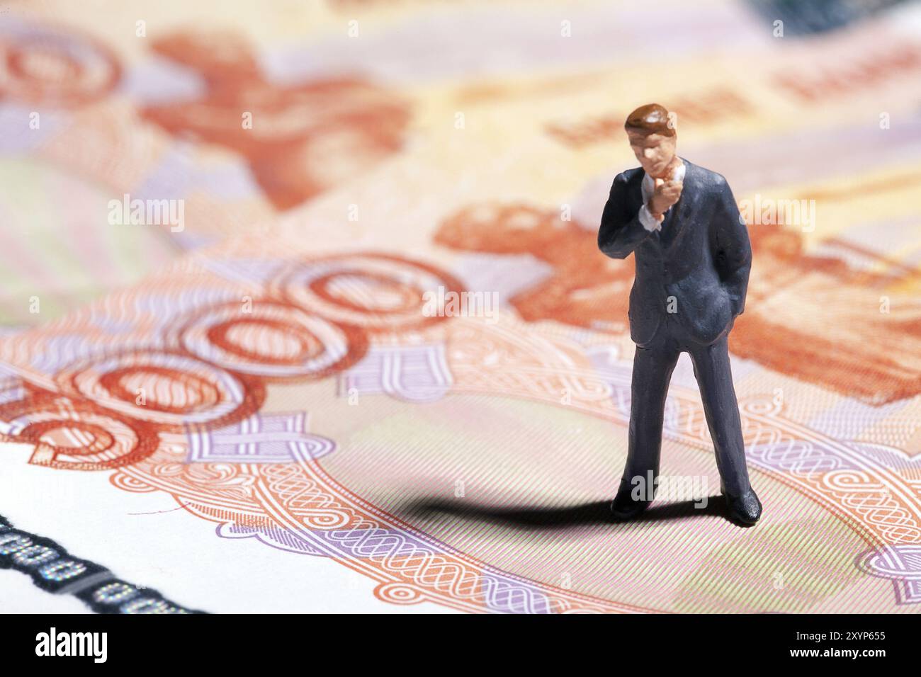 Miniaturfigur Geschäftsmann mit 5000 Rubel Banknote auf Hintergrund. Konzept Stockfoto