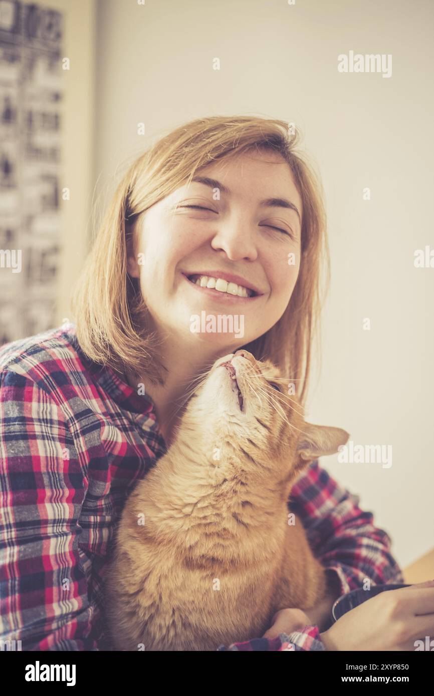 Red Tabby Katze ist Küssen eine junge schöne Mädchen, Nahaufnahme Stockfoto