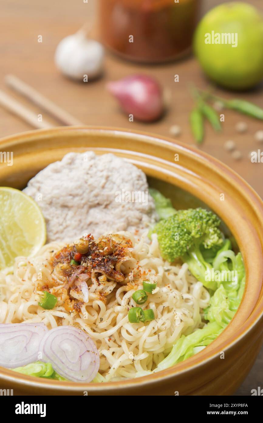 Heiße und scharfe Nudeln mit Schweinefleisch und Gemüse auf dem Holzhintergrund Stockfoto