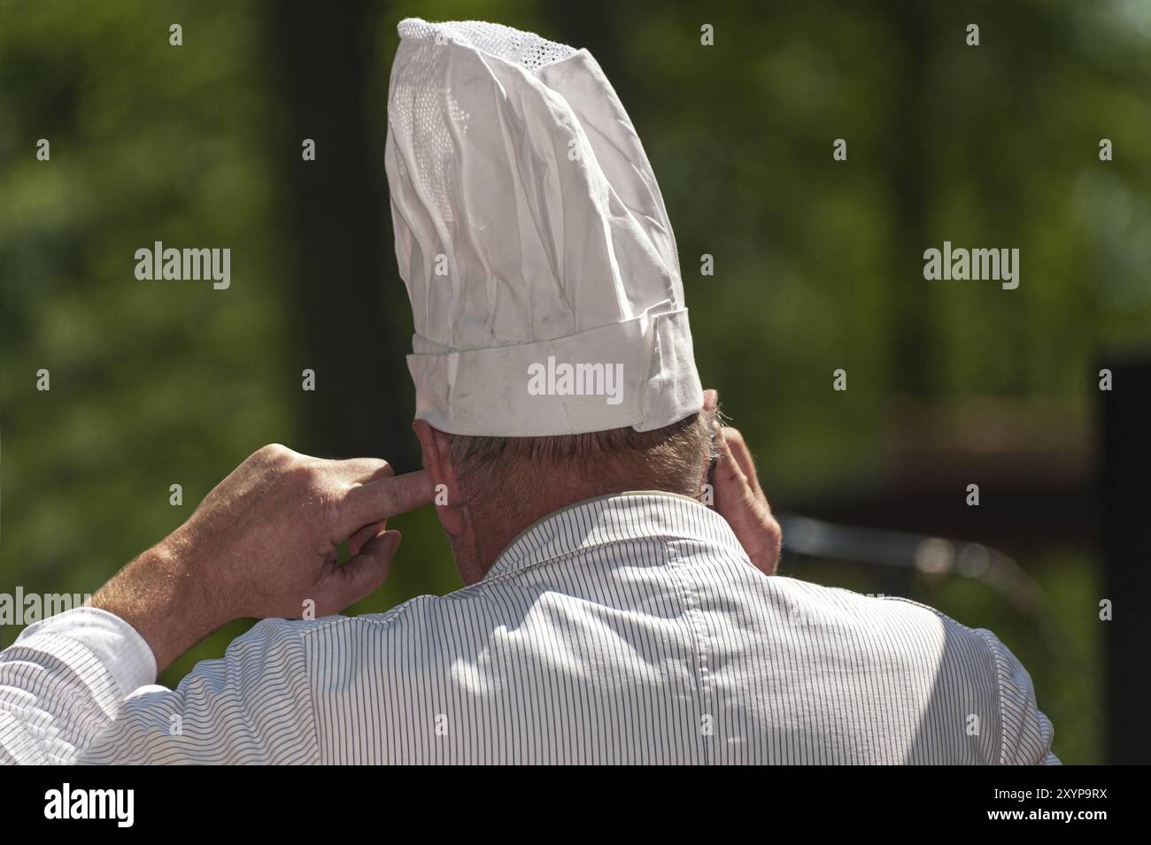 Kochen Sie mit dem Mobiltelefon und dem Finger im Ohr Stockfoto