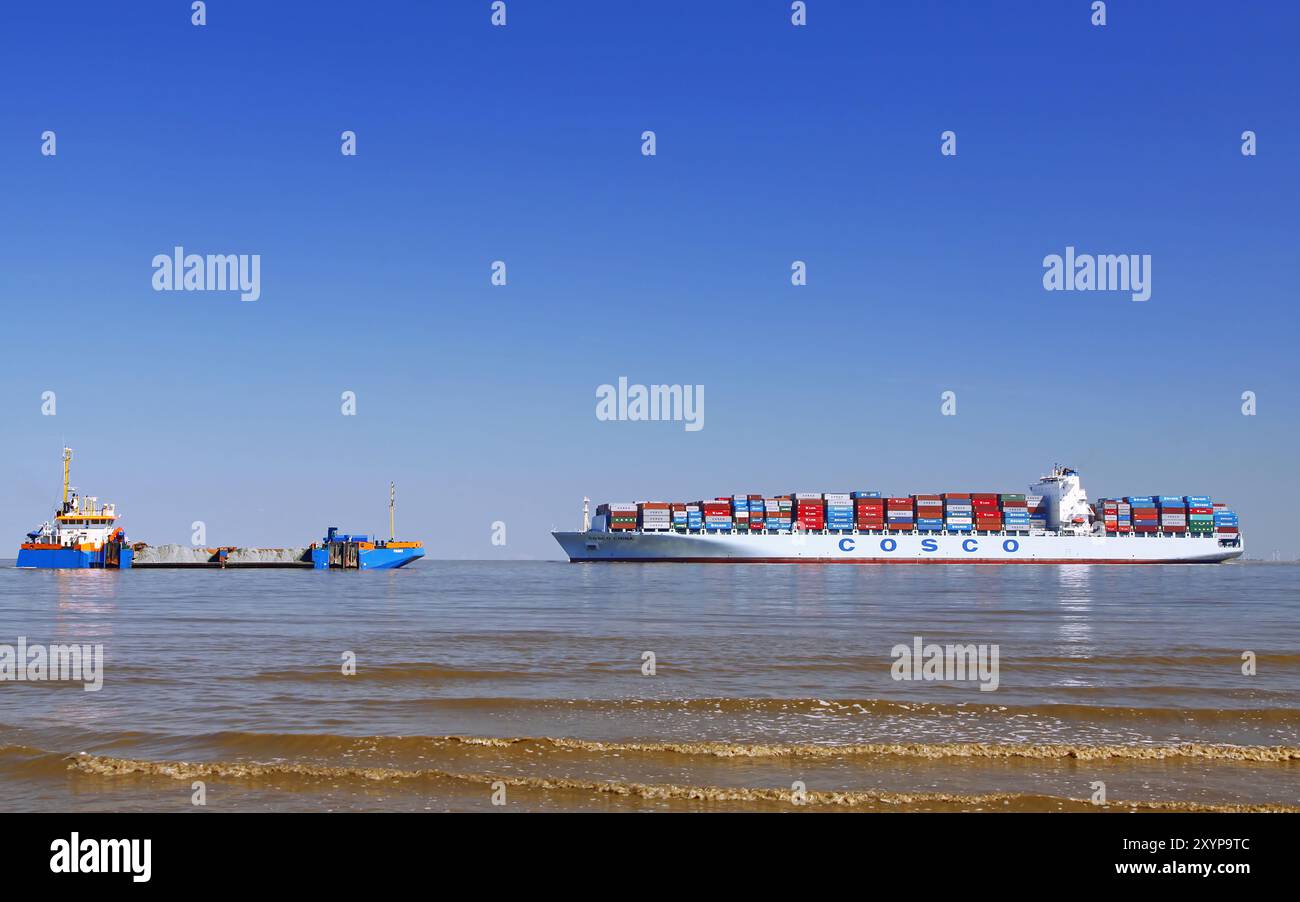 Frachtschiff Cosco China auf der Elbe, trifft auf den Bagger Frans Stockfoto