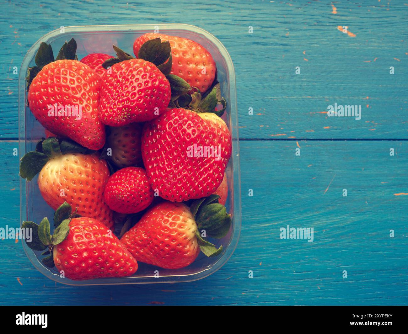 Frische Erdbeeren auf einem Küchentisch, gesundes Essen, flachen Farbe stilisiert, Platz für Text auf der rechten Seite Stockfoto