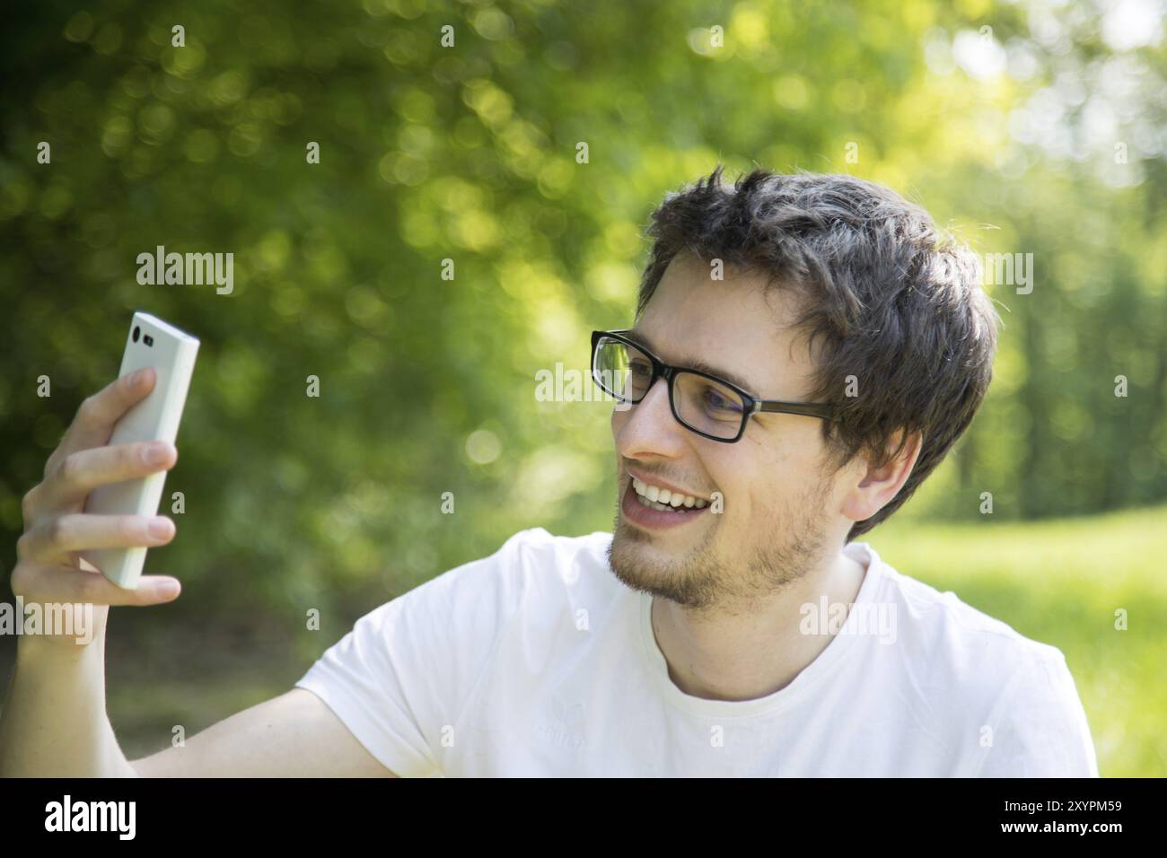 Der Mensch ist ein Bild mit seinem Handy, draußen im Park Stockfoto