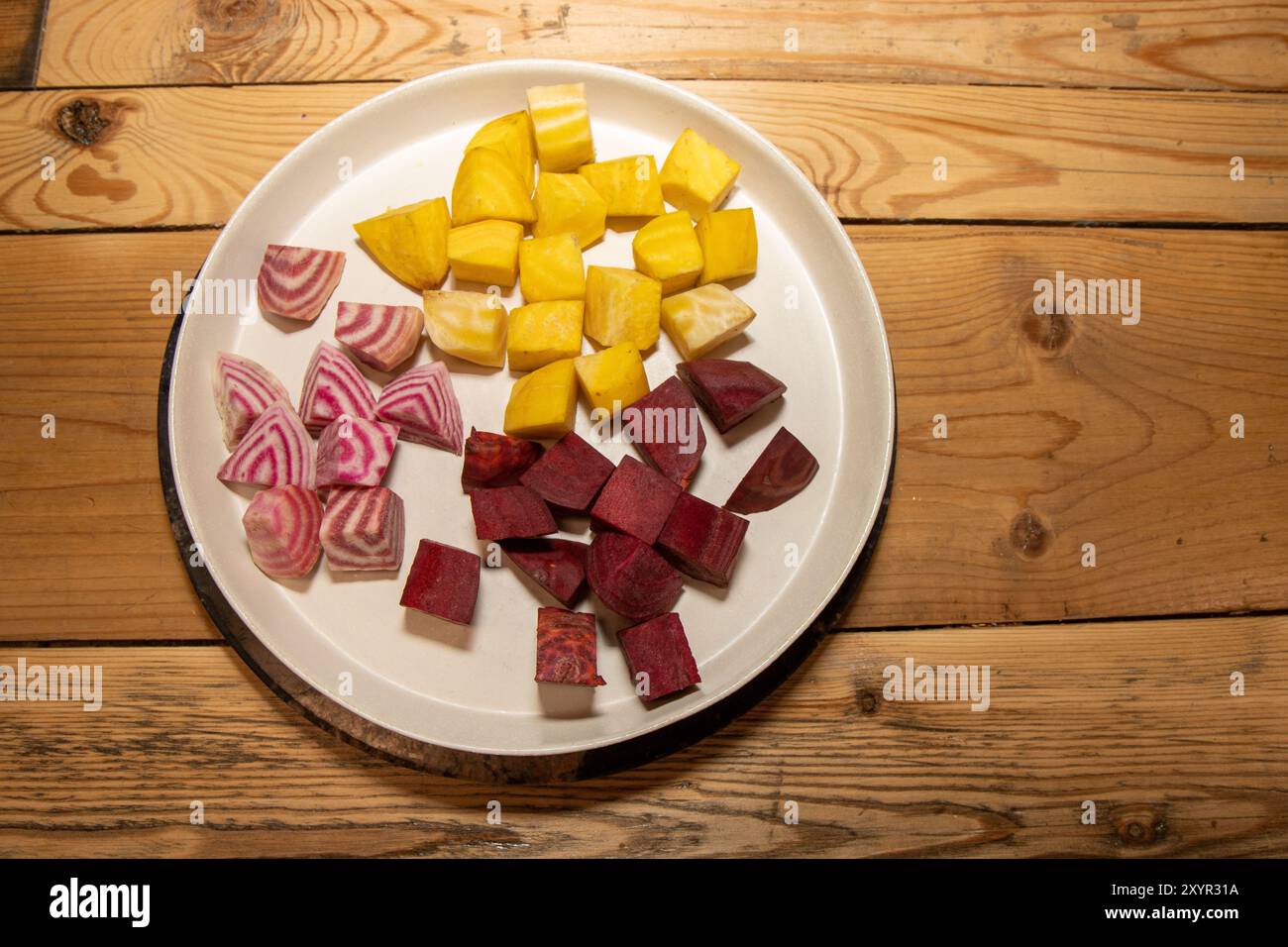 Ein Teller mit zerkleinerten Zutaten, die für eine köstliche Mahlzeit aus frischen gelben, rosa und weißen chioggia-Rüben bereit sind Stockfoto