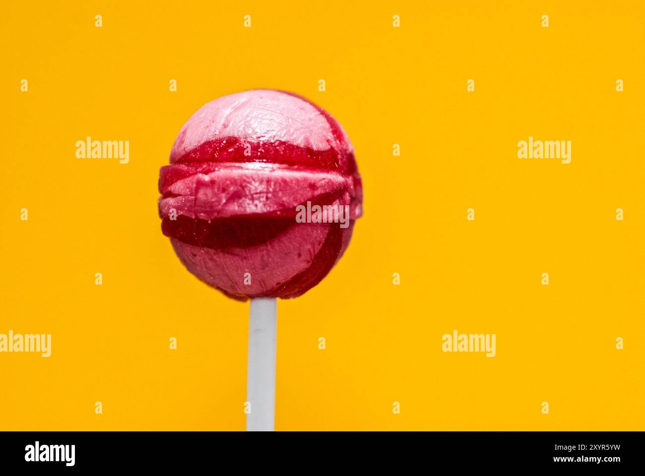 Rosafarbene Lollypop-Bonbons isoliert auf Gelb mit Textabstand Stockfoto Rosafarbene Lollypop-Bonbons isoliert auf Gelb mit Textabstand Stockfoto
