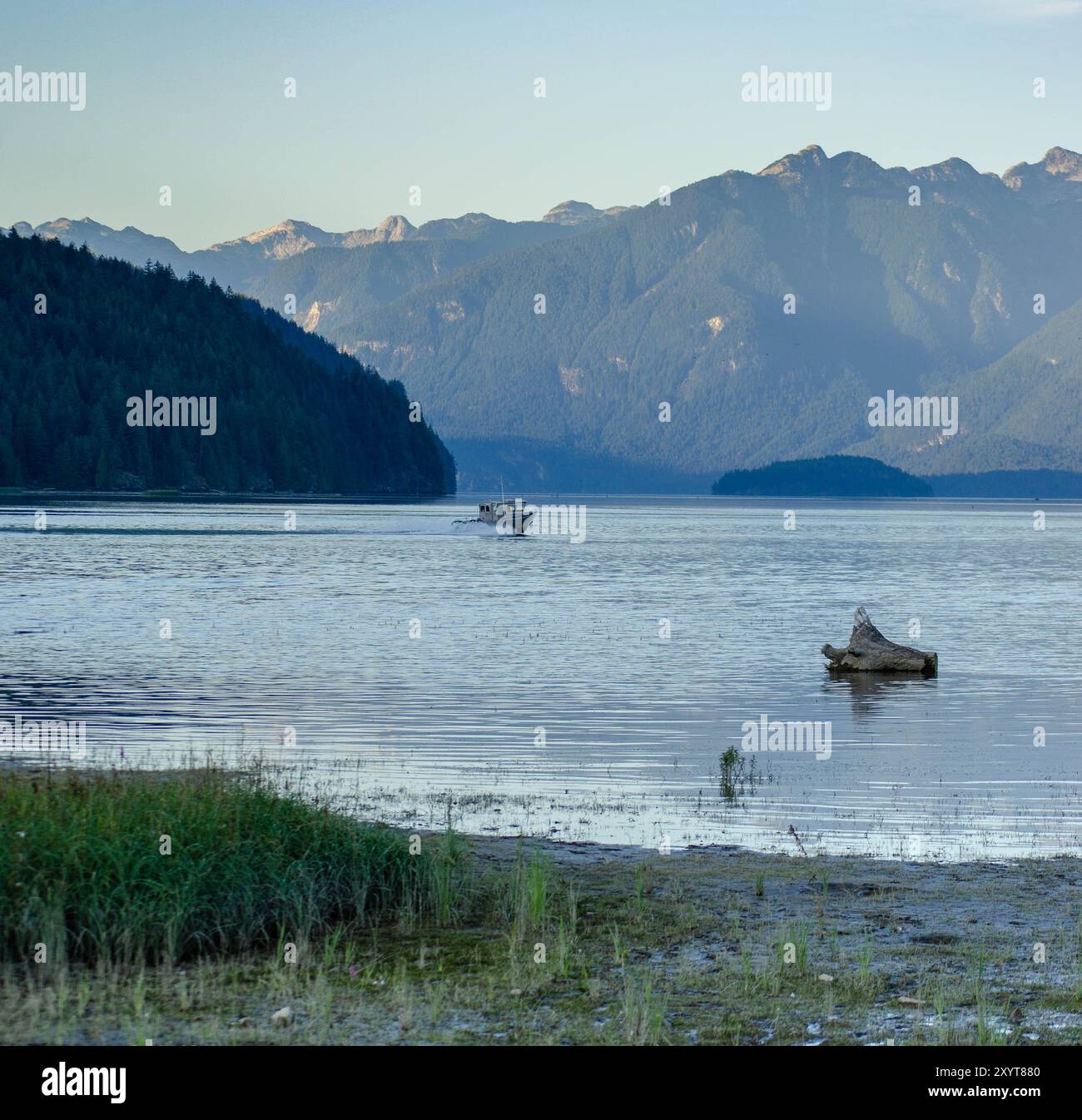 Fischerboot auf dem See mit Blick auf die Berge – ruhige Natur und Erholung im Freien Stockfoto