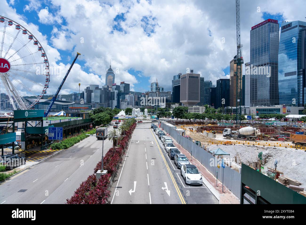 Hongkong, China - 03. Juli 2024 : Ein Blick von oben auf eine Straße, die durch Hongkongs Zentralbezirk führt, mit einem Riesenrad und Baustellen Stockfoto
