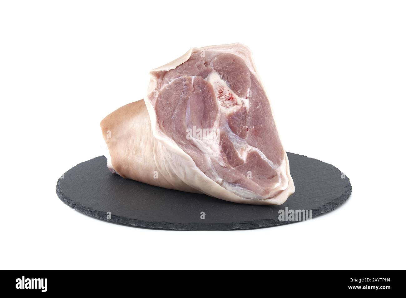 Frischer roher Schweinshaxe auf schwarzem Steinteller auf weißem Hintergrund Stockfoto