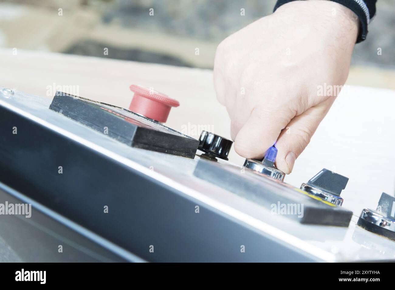 Eine Nahaufnahme der nicht gepflegten Hände des echten Zimmermanns rundet die Verarbeitung der Spanplattendetails der Möbel ab, indem sie die Kante abschneidet Stockfoto