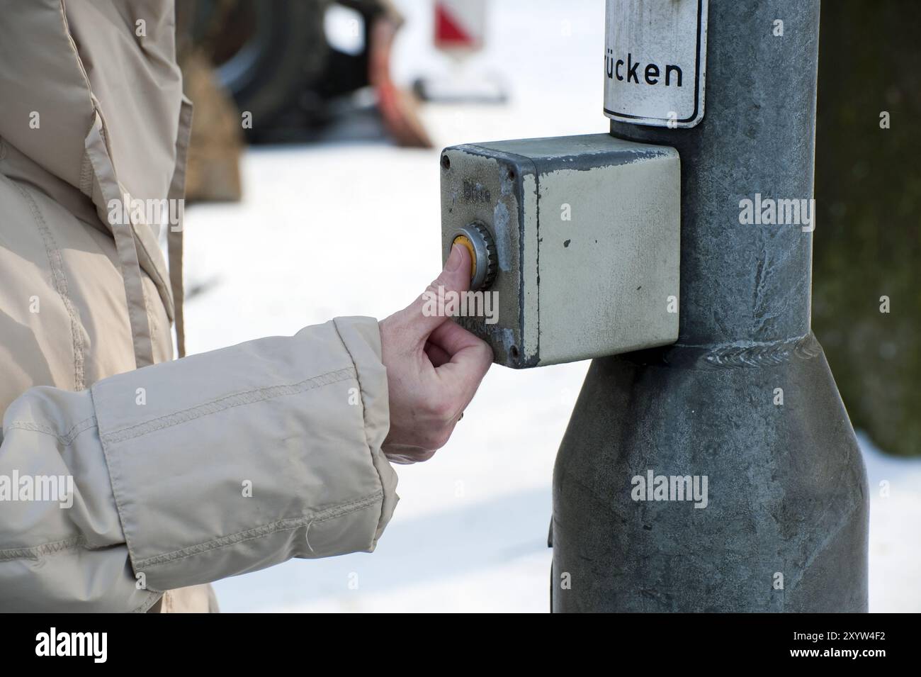 Die Person drückt die Hand auf den Knopf einer Ampelanlage Stockfoto