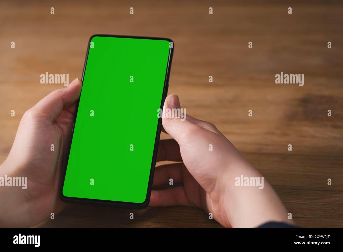Junge weibliche Hand Smartphone mit großen Leinwand auf Holz Eiche Tisch mit Platz kopieren, Vorlage Foto Stockfoto
