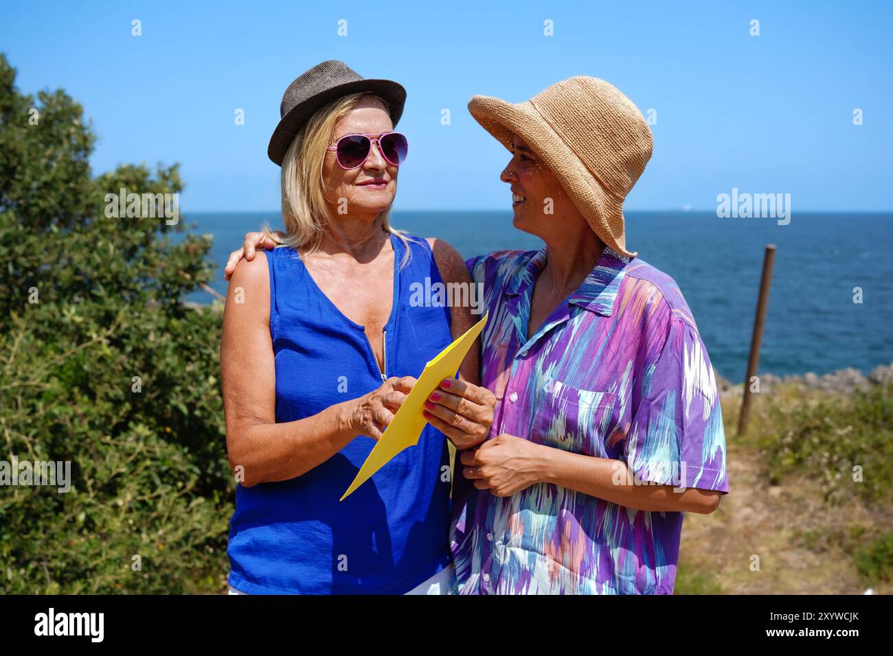 Eine Mutter und ihre Tochter sehen sich in ihren Sommerferien mit Komplizenschaft und Vertrauen an Stockfoto