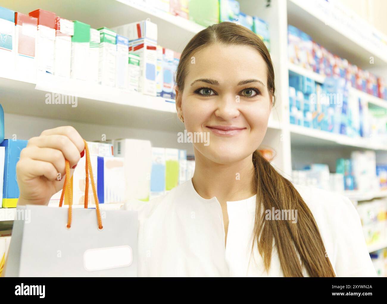 Nahaufnahme von einer Apothekerin mit Päckchen in der Hand in Drogerie Stockfoto