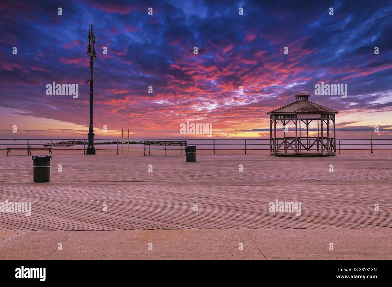 Coney Island Promenade mit Pavillon bei Sonnenuntergang mit wunderschönem Himmel, Strand ohne Menschen im Hintergrund, Brooklyn, New York City Stockfoto