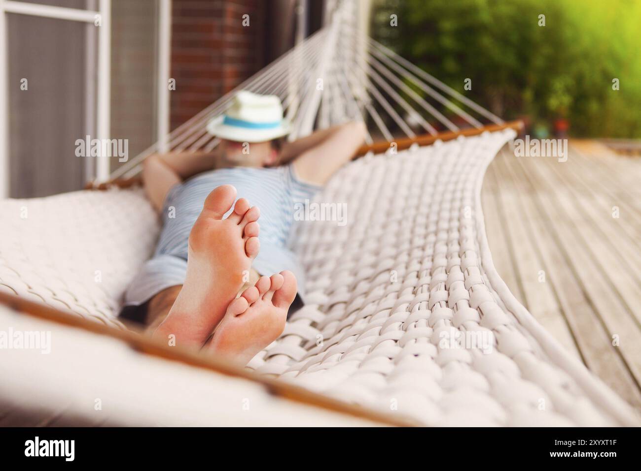 Zeit zum Faulenzen. Mann mit Hut in einer Hängematte an einem Sommertag Stockfoto