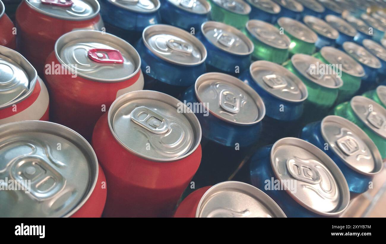 Von oben aus schließen sich Reihen von rot-blauen und grünen Aluminiumflaschen mit leckerem Getränk als Produkt für den Einzelhandel im Supermarkt an Stockfoto