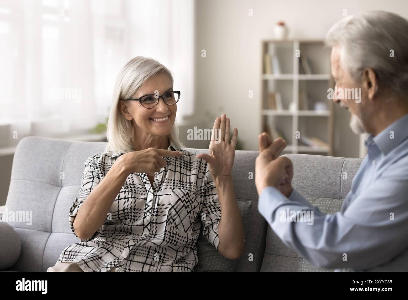 Ältere schwerhörige Frau mit Bleireden in Gebärdensprache Stockfoto