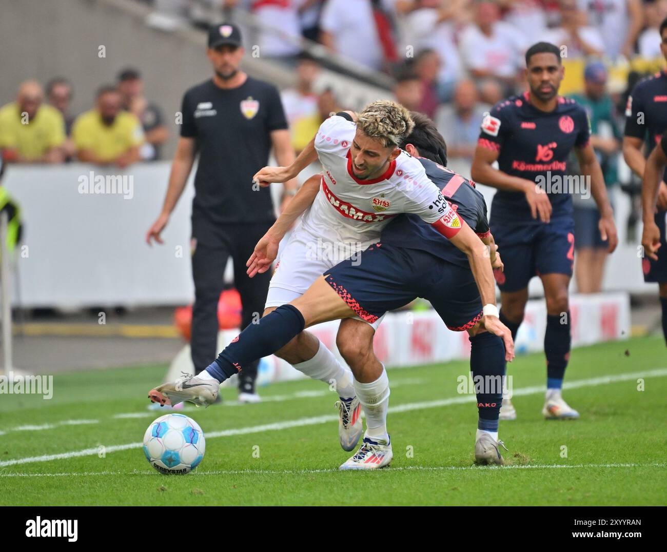 Stuttgart, Deutschland. 31. August 2024. Fußball: Bundesliga, VfB Stuttgart - FSV Mainz 05, Spieltag 2, MHPArena. Stuttgarter Atakan Karazor (l) im Duell mit Jae-Sung Lee von Mainz 05. Hinweis: Jan-Philipp Strobel/dpa - WICHTIGER HINWEIS: Gemäß den Vorschriften der DFL Deutschen Fußball-Liga und des DFB Deutschen Fußball-Bundes ist es verboten, im Stadion und/oder des Spiels aufgenommene Fotografien in Form von sequenziellen Bildern und/oder videoähnlichen Fotoserien zu verwenden oder zu verwenden./dpa/Alamy Live News Stockfoto